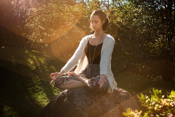 Woman in meditative posture in nature